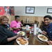 Two female residents and AJ Harris eating at holiday luncheon