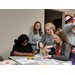 Auburn University volunteers helping a young male resident with craft