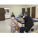 Pfizer vaccine being administered to lady holding a purse