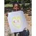 Youth resident holding up poster drawing with a yellow heart