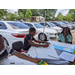 Youth residents at table under tent drawing and coloring posters