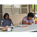 Residents sitting outside under tents at Wonderful Wednesday event