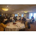 Employees sitting and talking at tables in banquet hall.