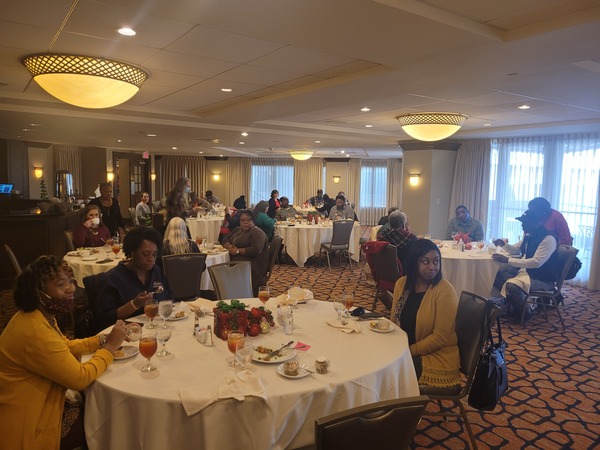 Employees sitting and talking at tables in banquet hall.