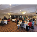 Employees at luncheon tables listening to speaker