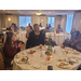 Marguerite White, Commissioner standing up at luncheon while other employees are seen clapping