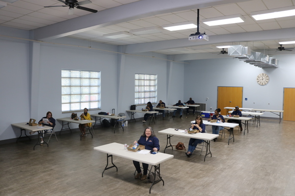 Aerial view of AHA Employee Meeting. Staff sitting behind desks in a spacious building.