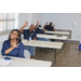 Four AHA employees smiling and waving at camera behind their individual desks.