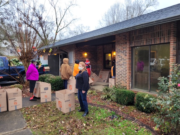 Individuals with boxes outside of brick building