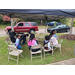 Youth sitting in folding chairs under tent talking