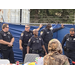 Auburn Police department officers standing talking near a blue fence