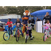 Aubie the Tiger looking at kids who received free bikes