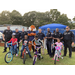 Aubie the Tiger and Auburn Police department posing with youth receiving free bikes
