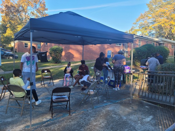 Residents hanging out under tent at tailgate