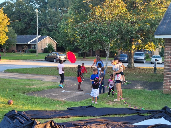 Youth playing outside with jump ropes and balls before movie begins