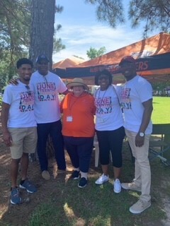 Group of five Auburn Housing Authority staff members posing under a tree outside at the Juneteenth Celebration.