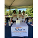 Auburn Housing Authority staff members posing under a tent and behind a Auburn Housing Authority vendor table.