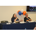 AHA Staff at registration table for Landlord Symposium behind them are orange, white, and blue balloons.