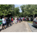 Individuals lined through parking lot waiting for their chance at the free items available at the LaFayette Housing Authority Farmers Market.