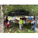 LHA Farmers Markets being setup with volunteers unpacking items from card board boxes,