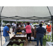 Individuals attending RHA Farmers Market are being help to package and tote their selected food items.