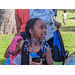 Young girl with braids is walking and looking to the right with a new pink bookbag on her shoulder.