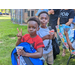 Young boys are seen holding new backpacks and snow cones, while one is giving the peace sign.