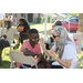 Young boy getting his face painted under a tent at the tailgate event