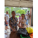 A boy and girl are smiling while standing in front of a table to receive back to school supplies.