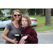 Female and child are posing up close with a cup and bag of popcorn in hand.