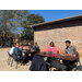 Multiple staff members outside seated at tables during Iron Bowl tailgate event 