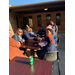 Staff members sitting at table with soda cans at Iron Bowl Tailgate event