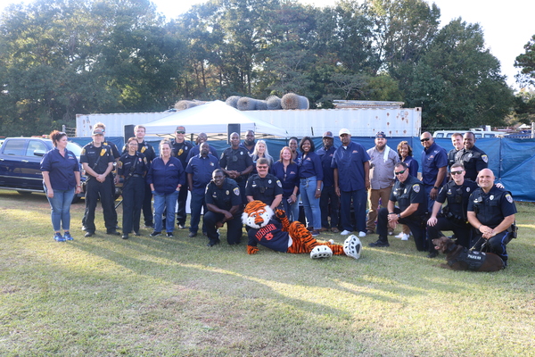Group of police officers, employees, and Aubie at Operation CommUnity