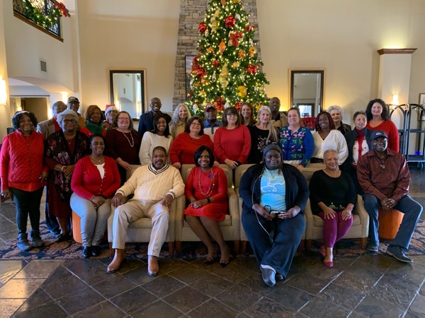 All employees, commissioners, and guest posed in front of Christmas tree 