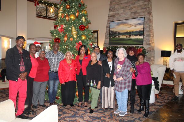 Employees and Commissioners at the Christmas Luncheon posing in front of Christmas tree
