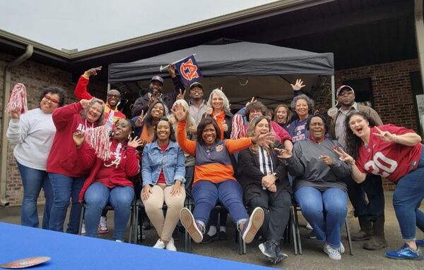 AHA Employees at the Pre-Iron Bowl Tailgate in their Alabama and Auburn gear cheering for their team