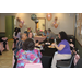 People are sitting and socializing at a retirement party with balloons in the background