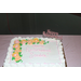 Sandra's retirement cake with yellow flowers and white icing and the text Happy Retirement Sandra