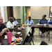  Staff members around table eating and talking 