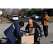  Commissioner White helping a resident with a box at the Christmas Farmers Market 