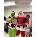  The Grinch and Santa holding a youth resident in their arms 