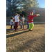  The Grinch walking with children following behind him on the outside lawn 