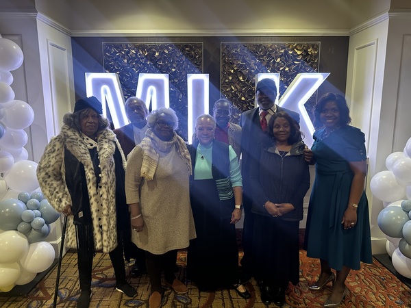 Auburn Housing Authority Commissioners and staff posed in front of MLK letters at the breakfast