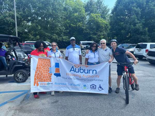 Mrs. Sharon Tolbert joined AHA Board Commissioners Nolan Torbert and Rene Waldrop for the event, alongside Auburn City Councilwoman Connie Taylor and Mayor Ron Anders holding a Auburn Housing Authority banner.